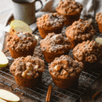 Freshly baked apple cinnamon streusel muffins with crumb topping served on a rustic tray