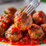 Juicy chicken meatballs simmered in marinara sauce and garnished with fresh basil