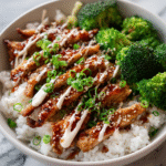 Easy sticky chicken bowls with glazed chicken, steamed rice, and fresh vegetables served in a white bowl