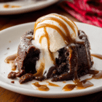 Decadent chocolate lava cake with molten peanut butter filling oozing out onto a white plate