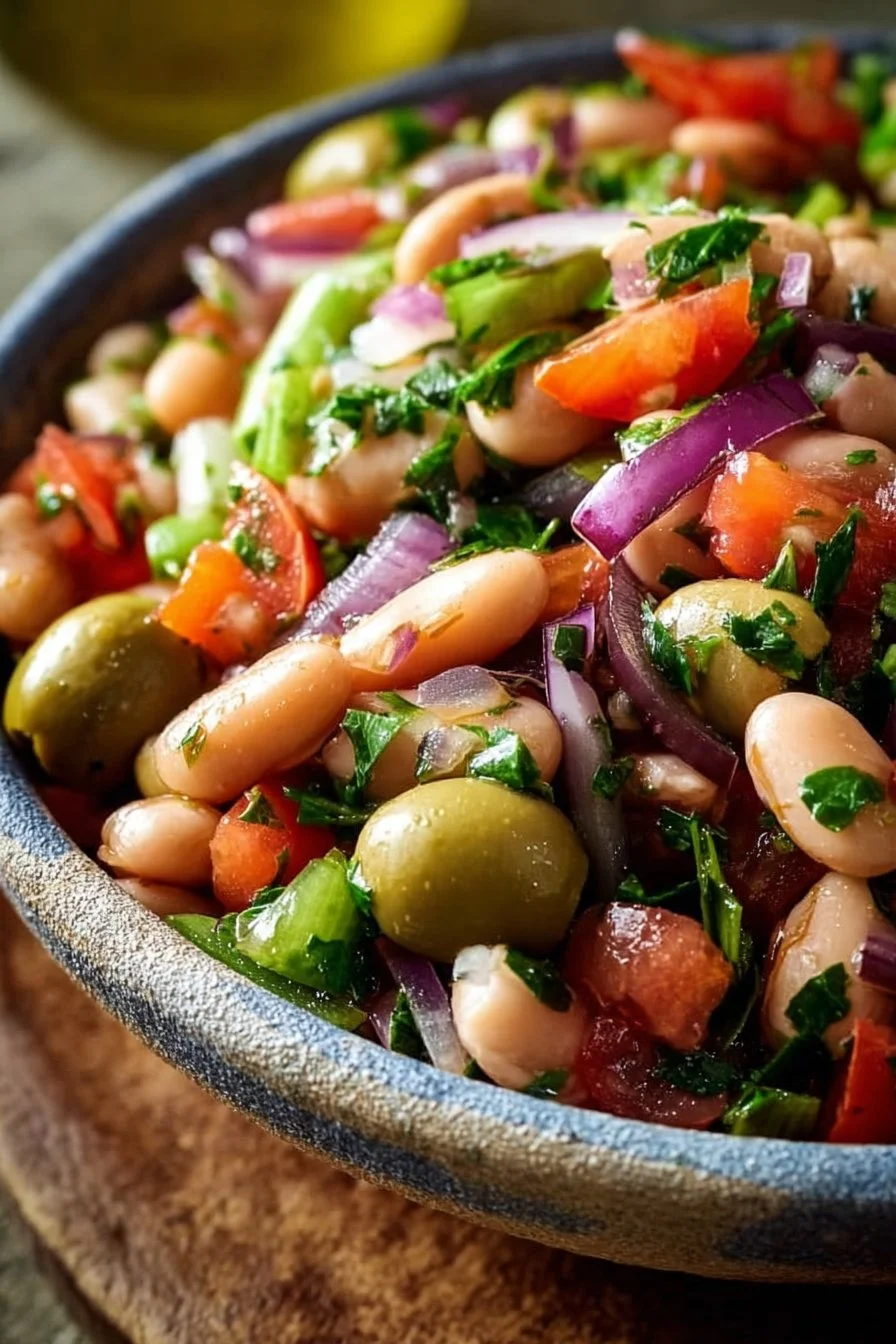 Easy Mediterranean Bean Salad featuring olives and onions in a colorful bowl