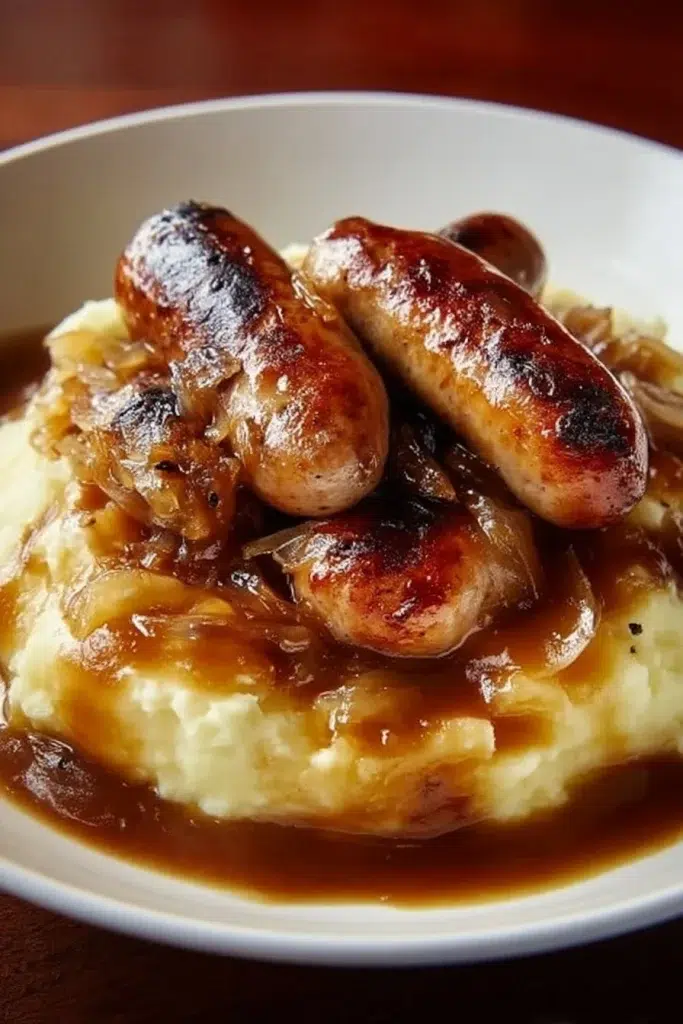 Delicious plate of bangers and mash served with onion gravy, a classic comfort food